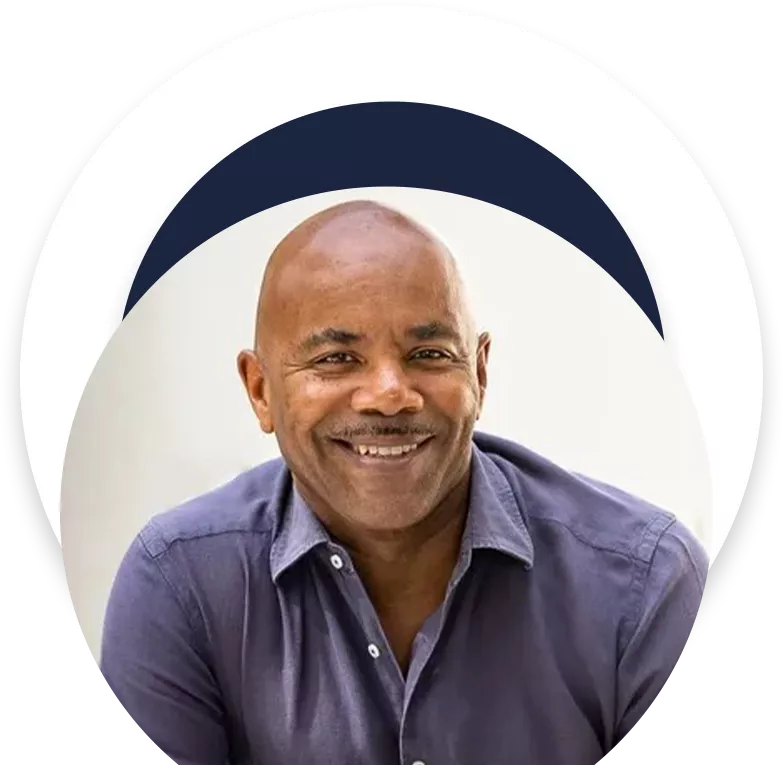 A man with a shaved head smiling for the camera.