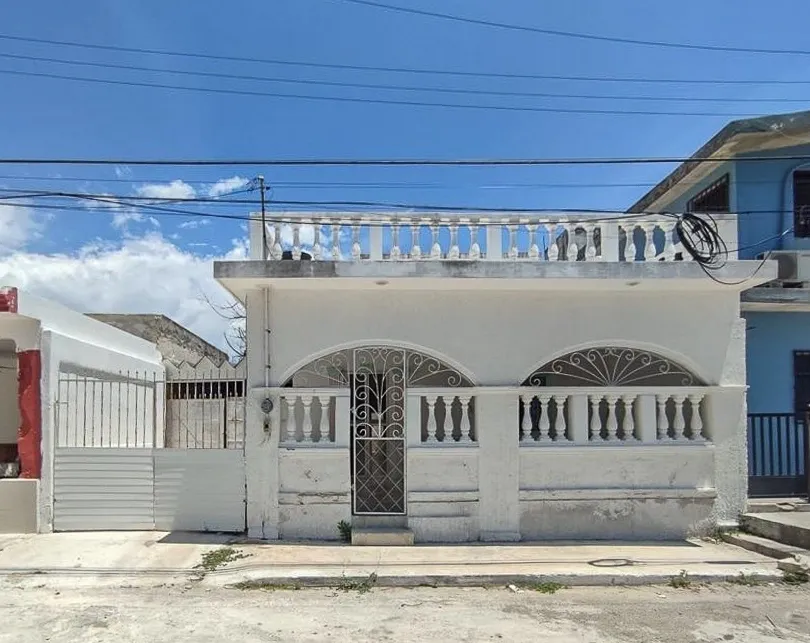 A white building with a balcony on top of it.