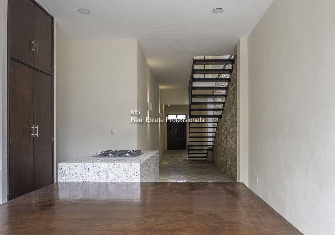 Minimalist hallway with floating staircase and marble platform.