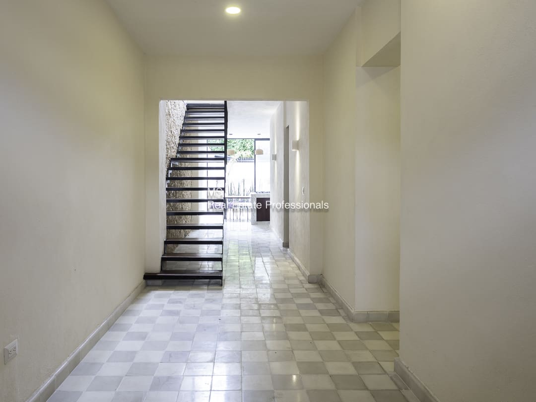 Modern interior with staircase and patterned floor tiles.