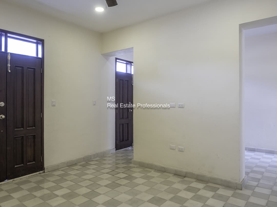 Empty room with tiled floor and two doorways.