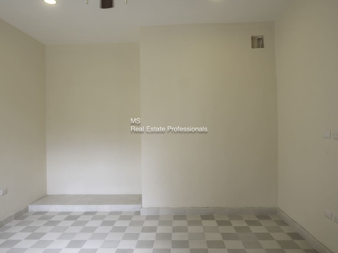 Empty room with tiled floor and plain walls.