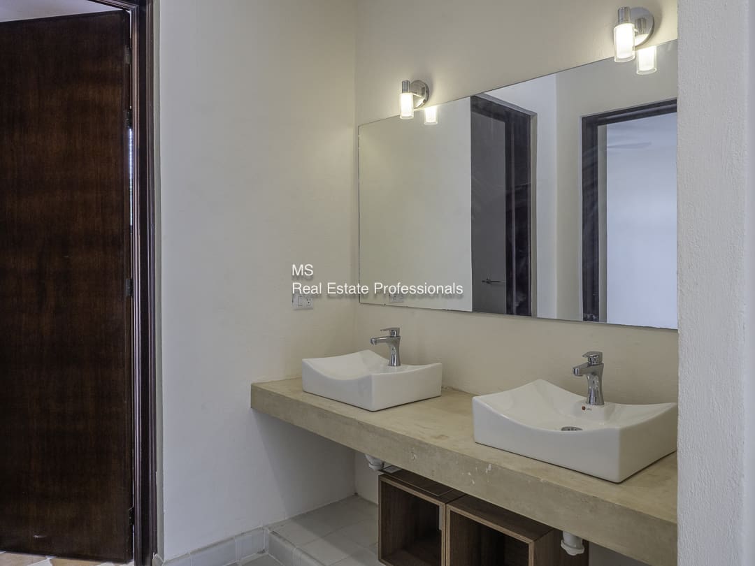 Modern bathroom with double sinks and large mirror.