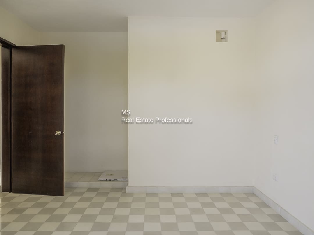 Empty room with white walls and checkered floor.