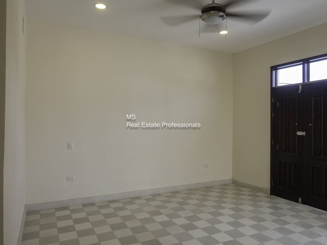 An empty room with tiled floor and ceiling fan.