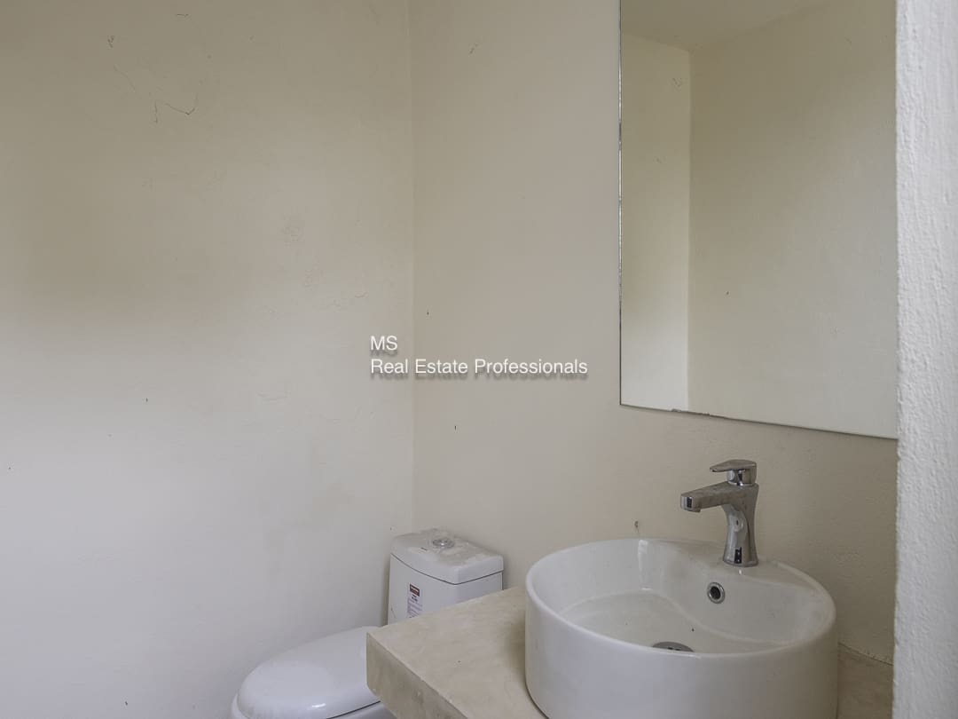 Minimalist bathroom with a round sink and a mirror.