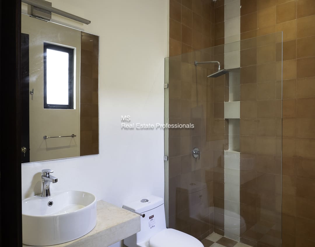 Modern bathroom with a glass shower enclosure and wooden accents.