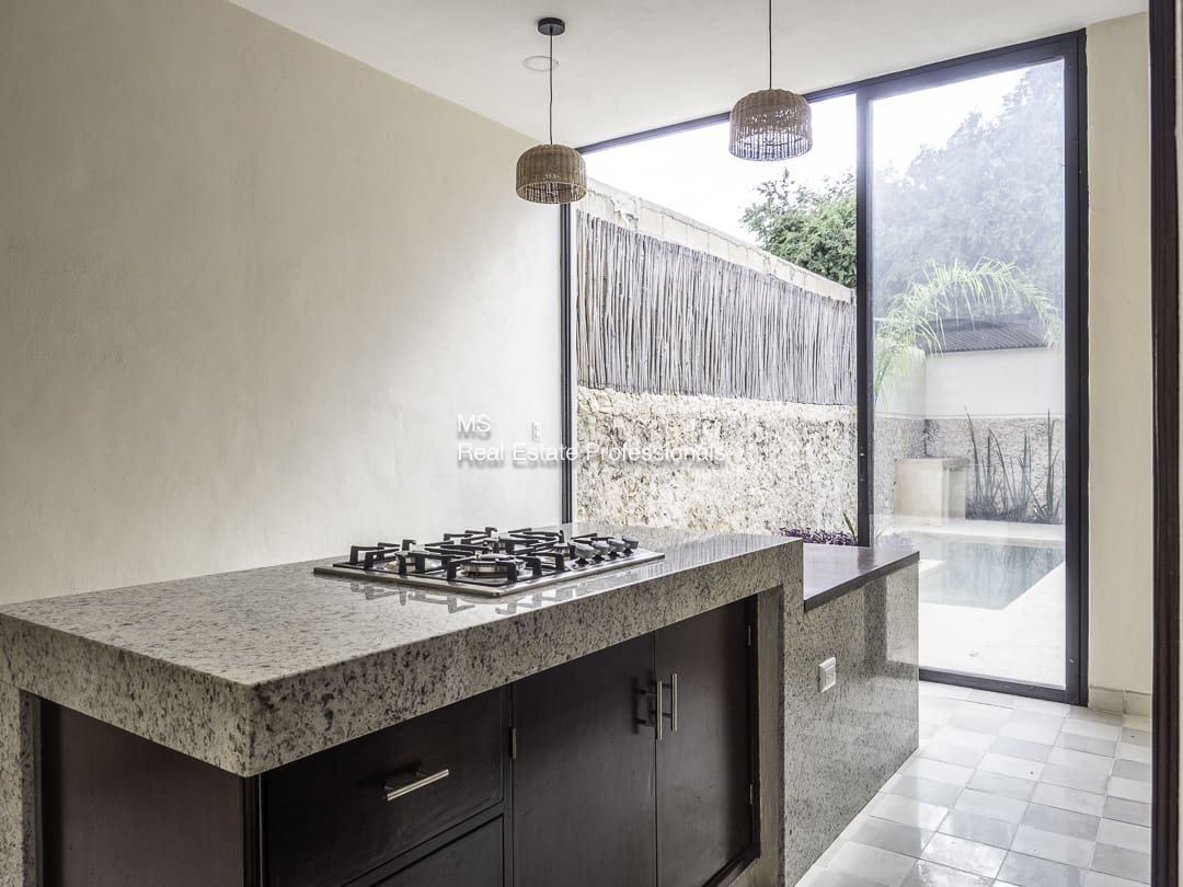 Modern kitchen with concrete countertop and gas stove.