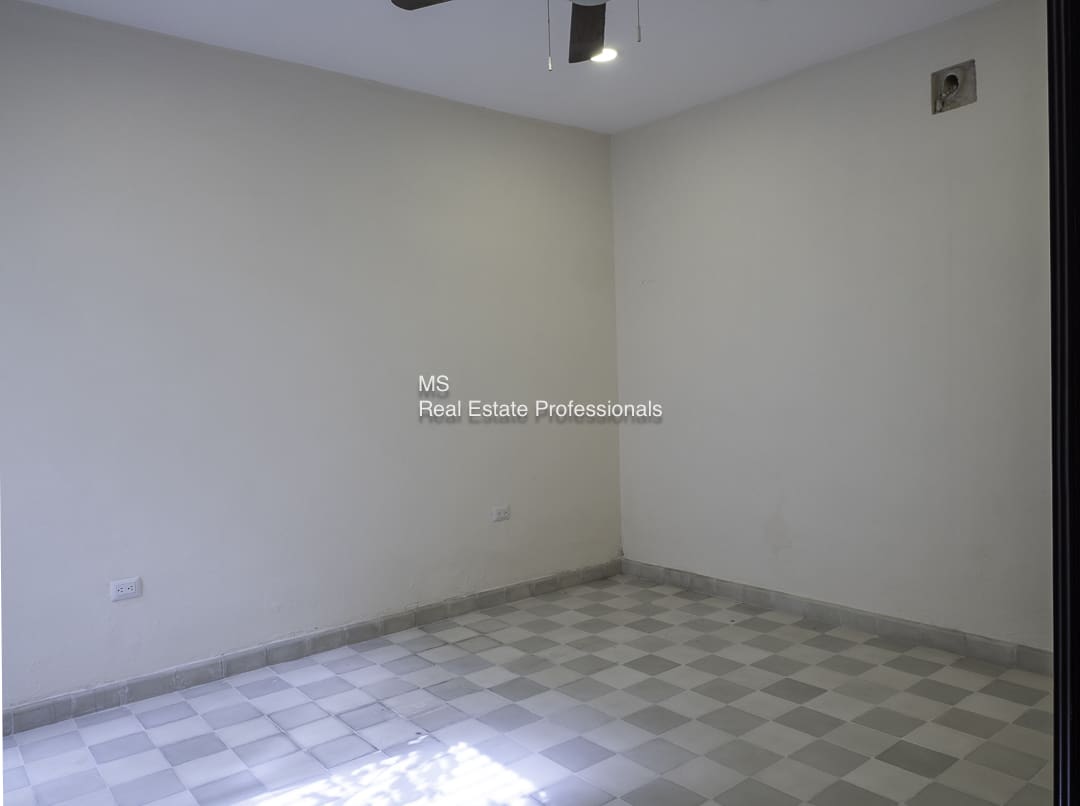 Empty room with tiled floor and plain walls.