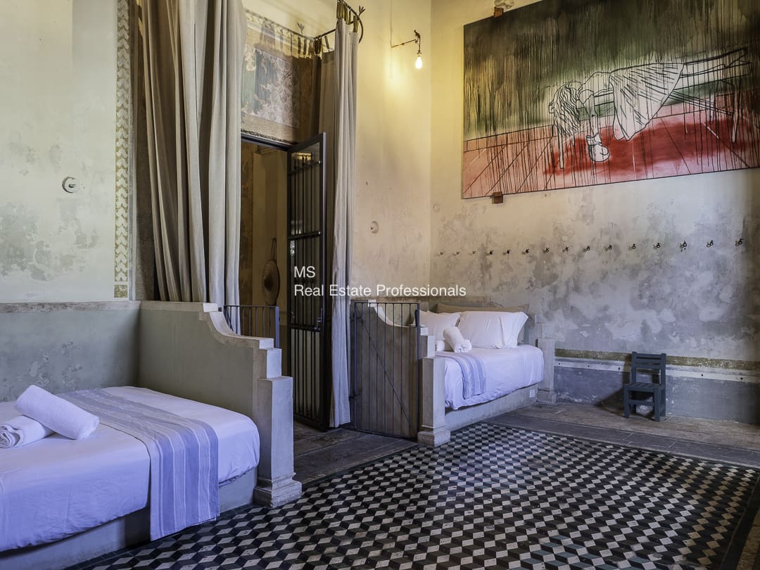 Cozy living room with white armchairs and patterned floor tiles.