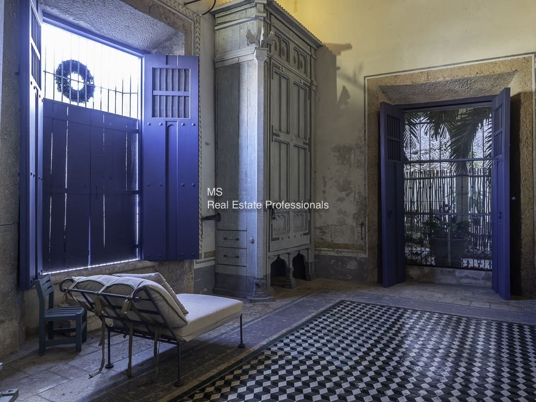 A vintage room with a checkered floor and ornate furniture.