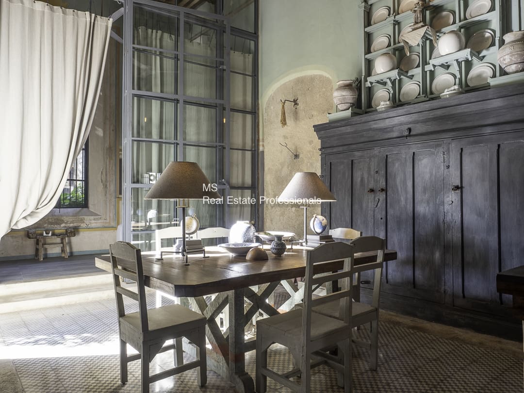 Rustic dining table set with lamps and ceramics in a cozy room.