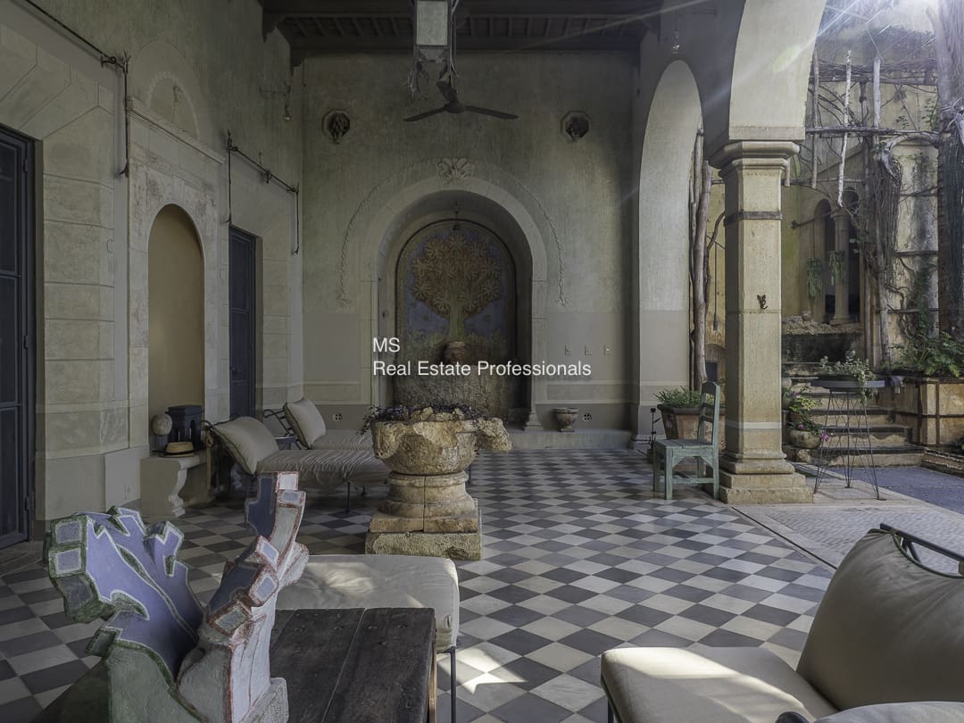 Interior of an old church with stone benches and checkered floor.