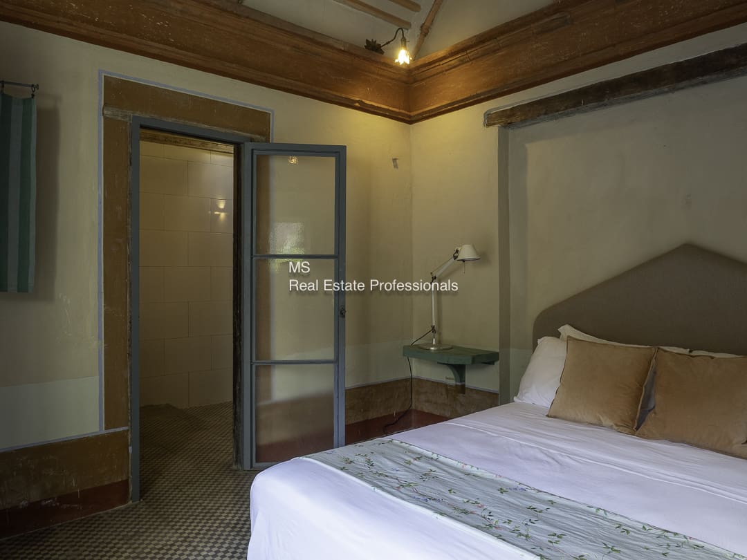 Cozy bedroom with wooden ceiling and glass door.