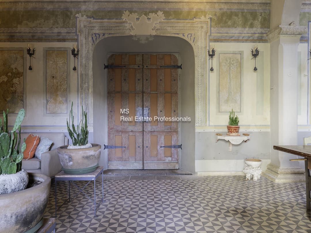 Rustic room with a wooden door and patterned tile floor.