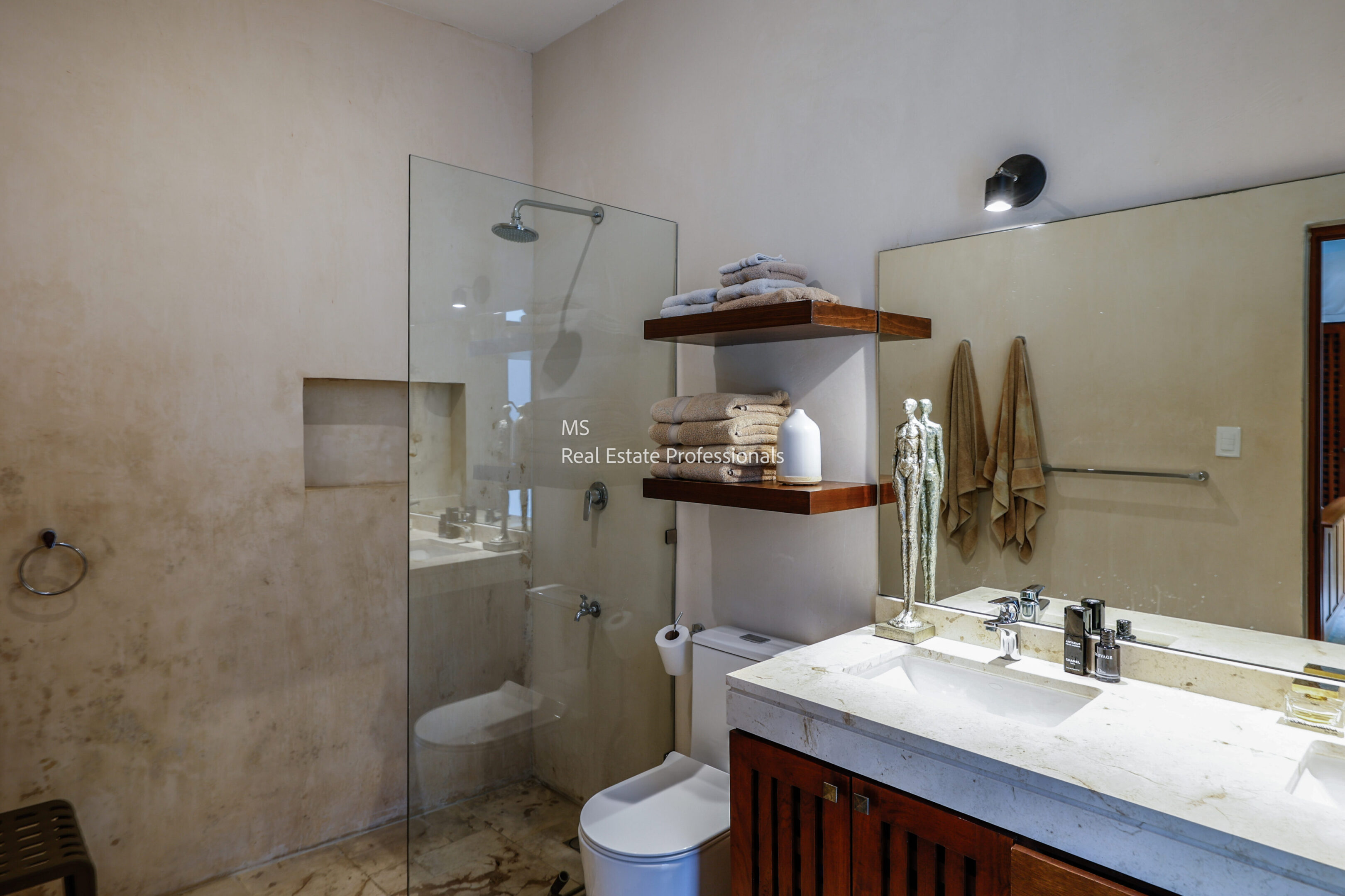A modern bathroom with a glass shower enclosure and wooden shelves.