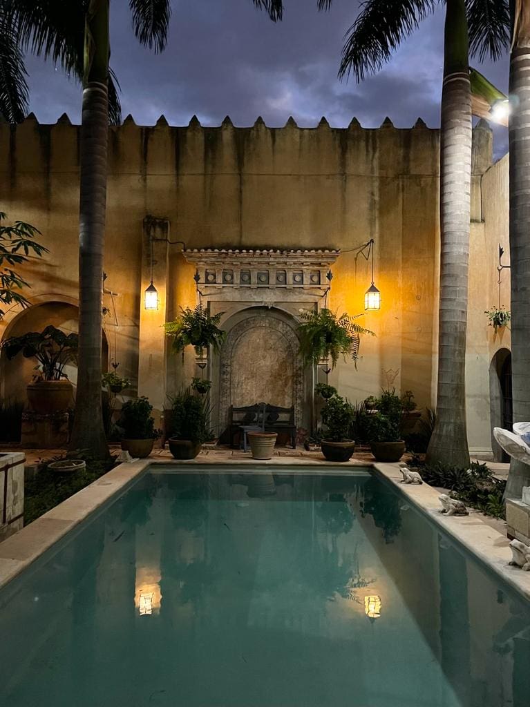 A serene pool area with warm lighting at night.