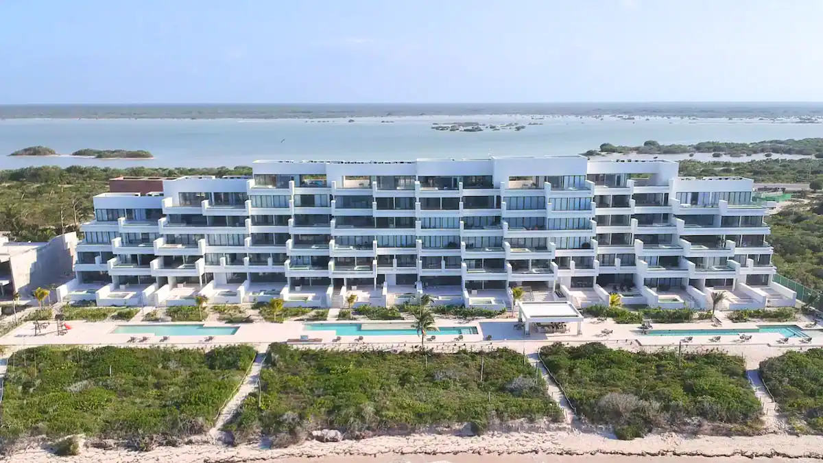 A modern beachfront resort with multiple balconies overlooking the ocean.