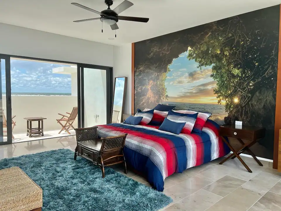 Cozy bedroom with a patriotic-themed bedspread and a scenic wall mural.