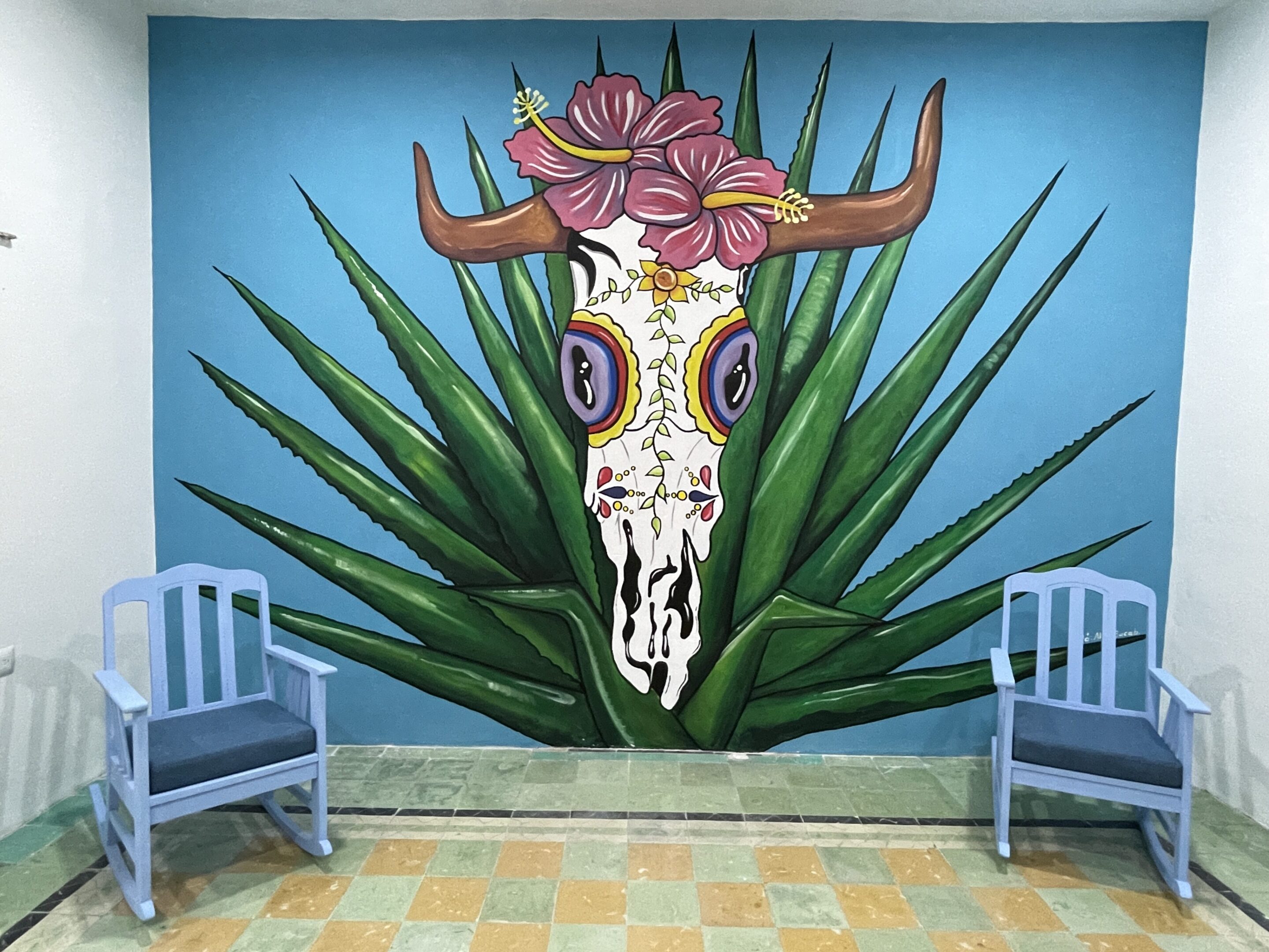 A mural of an animal skull with flowers on it.