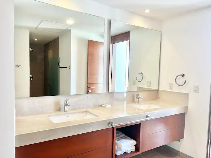 Modern bathroom with double sink and large mirror.