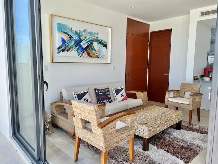 Modern living room with wooden furniture and colorful abstract wall art.