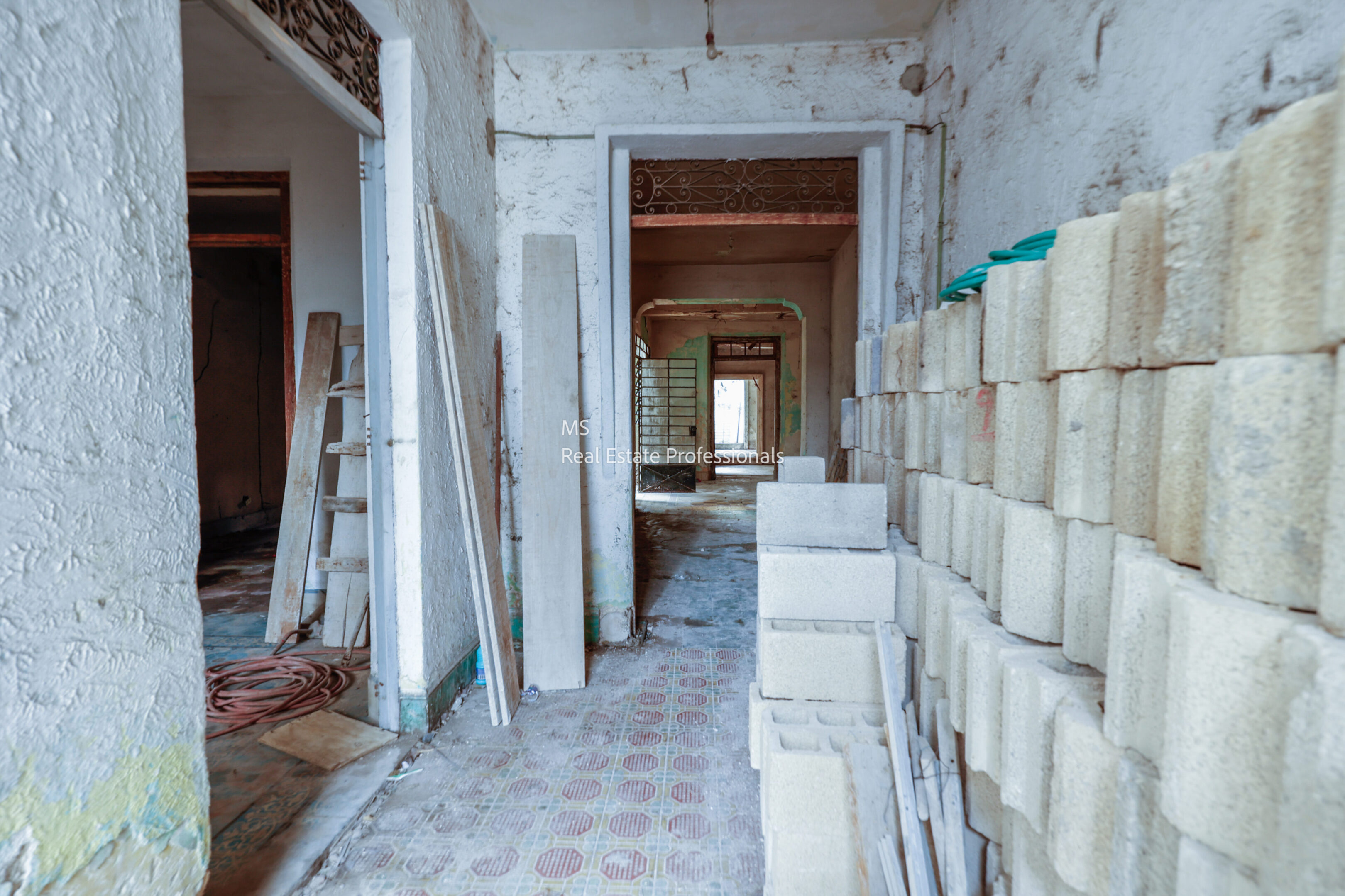 A room with many stacks of bricks and some walls