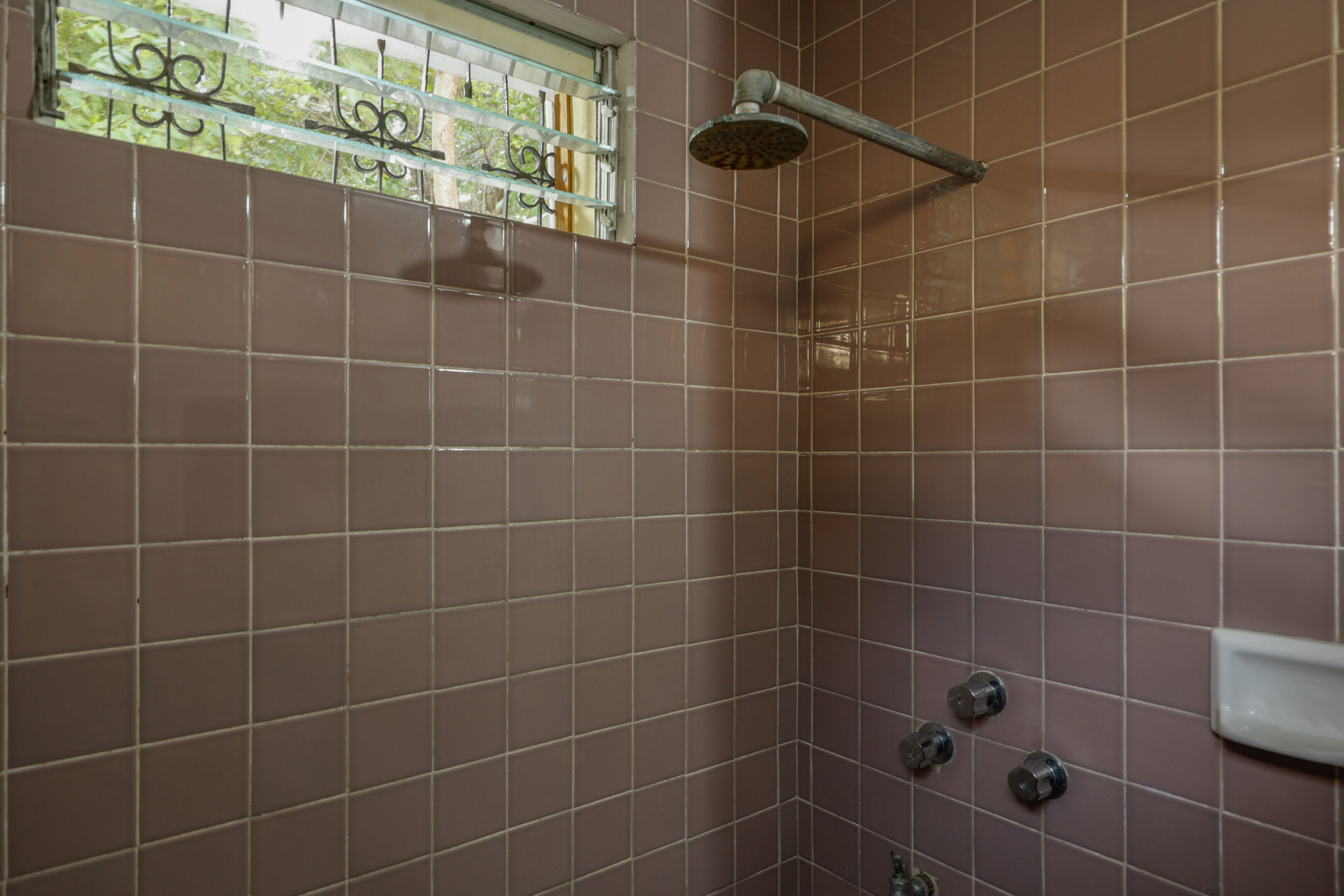 A shower with a window in the corner of it