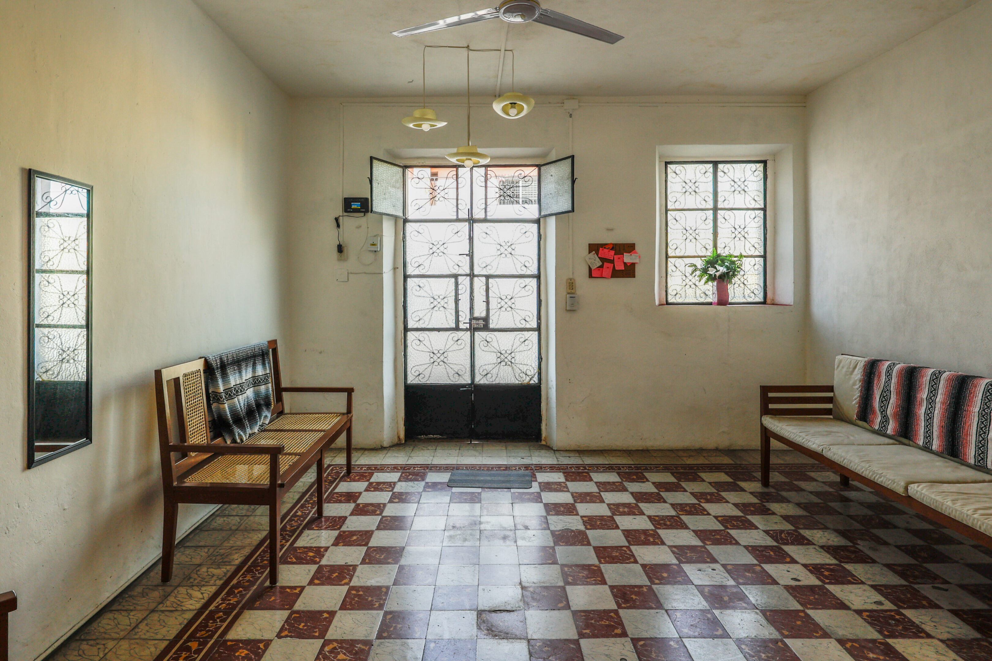 A room with checkered floor and two benches.