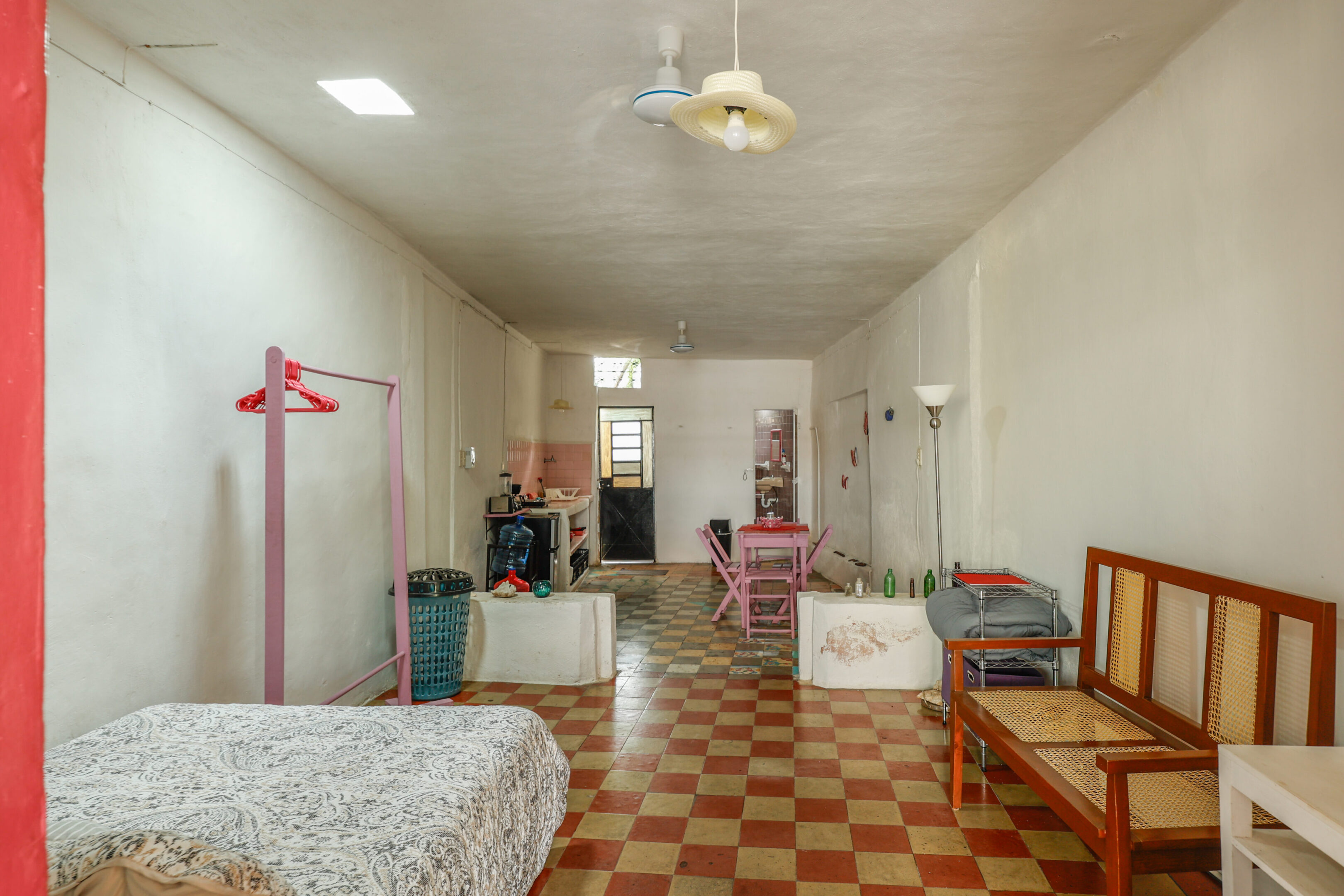 A room with a bed, chair and several other items.