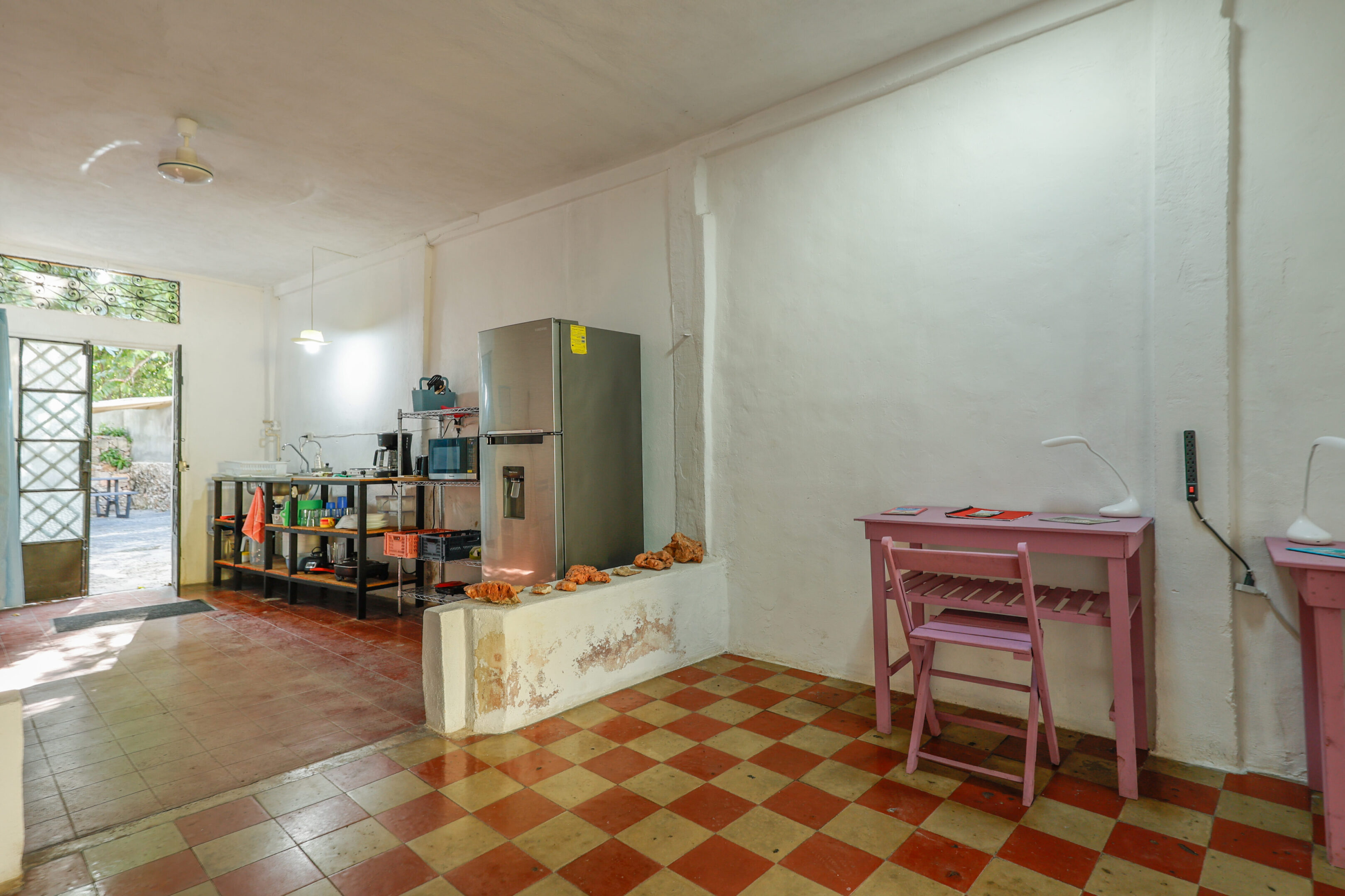 A room with a desk and chairs in it