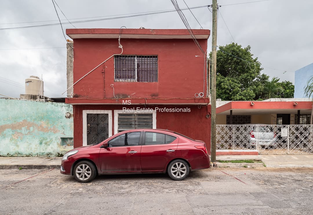 A red car parked in front of a building.