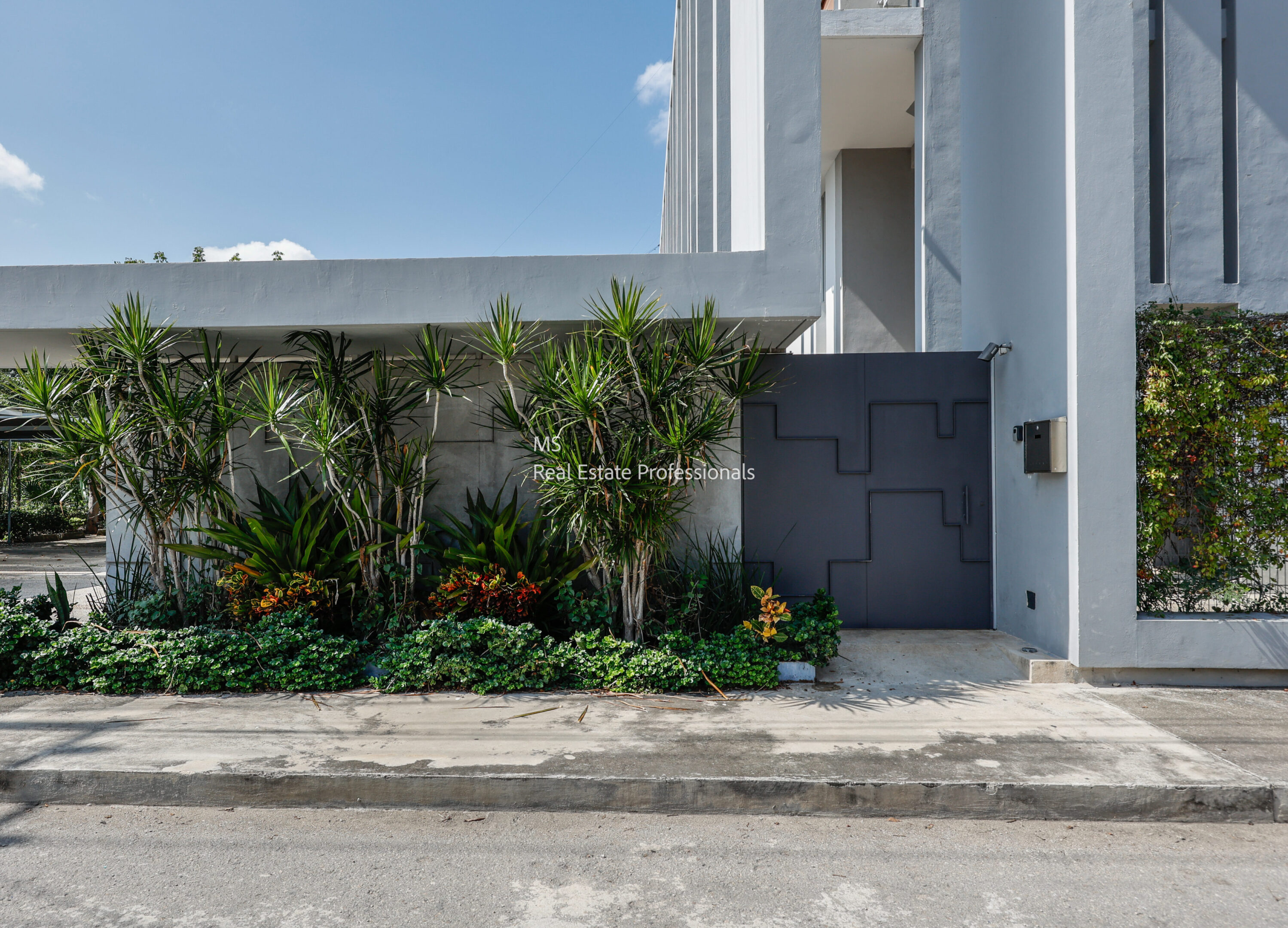 A building with plants growing in front of it.