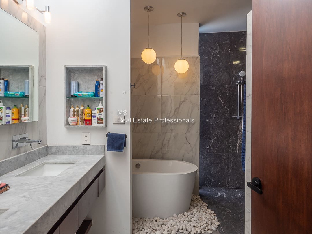 A bathroom with a tub, sink and shower.