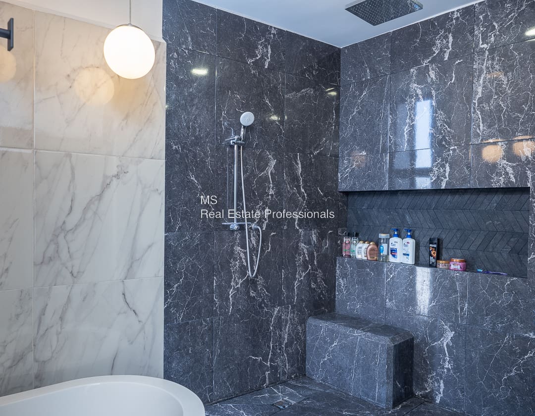 A bathroom with marble walls and floors.