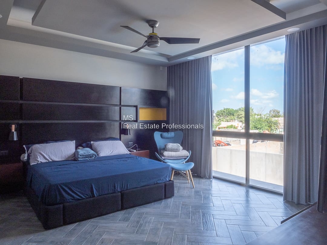 A bedroom with a large bed and a balcony