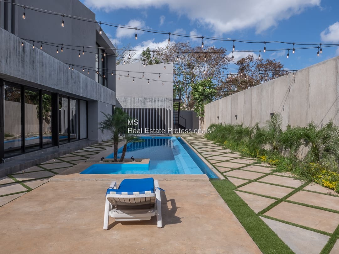 A pool with a blue chair and white chairs