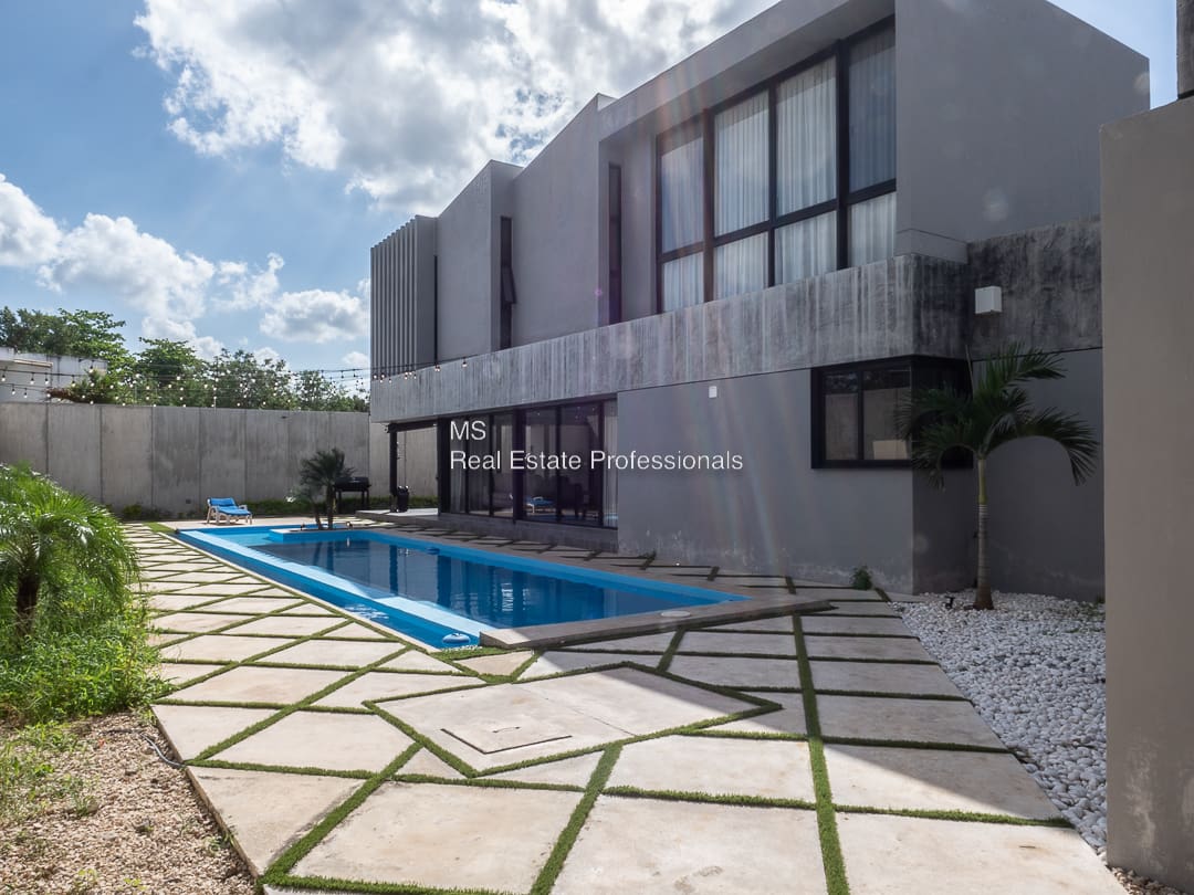 A large pool in front of a house.