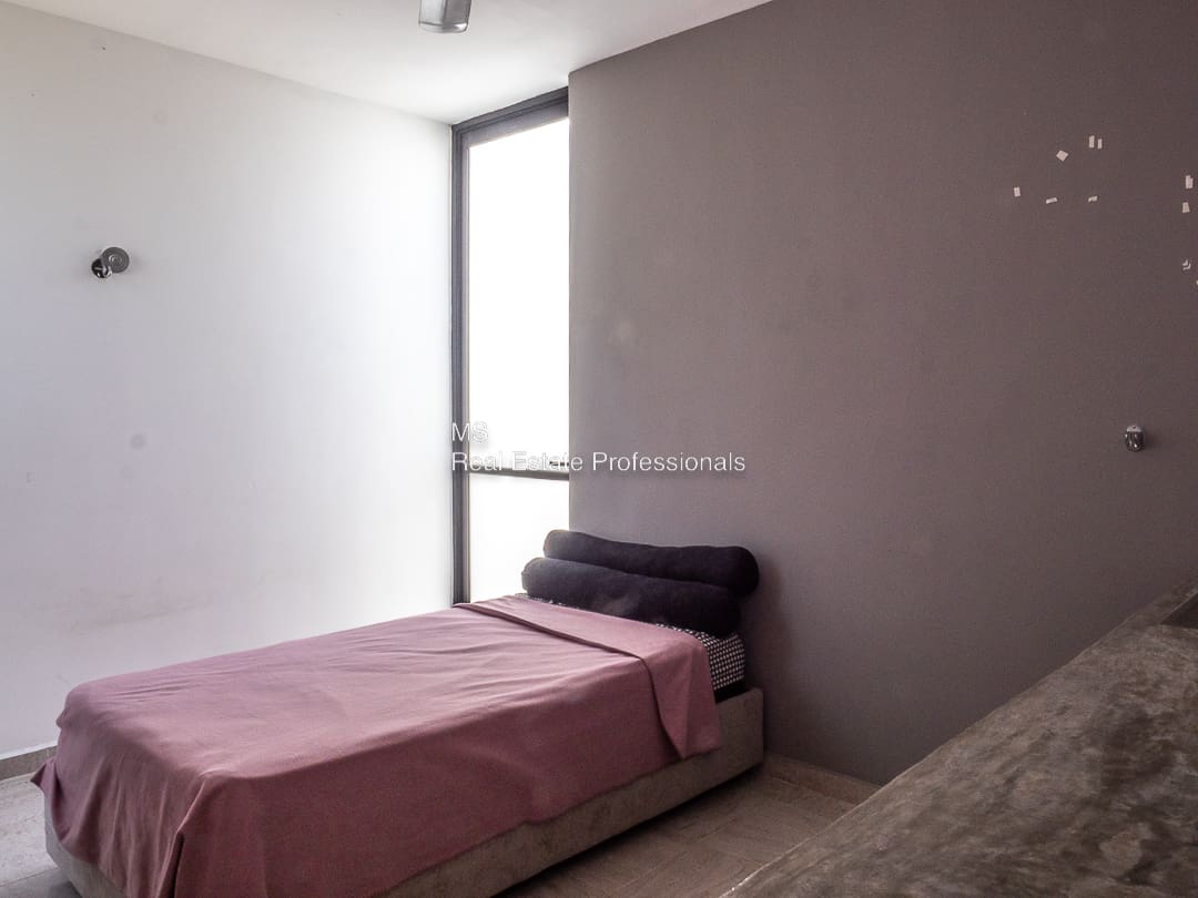 A bed room with a pink bedspread and a window