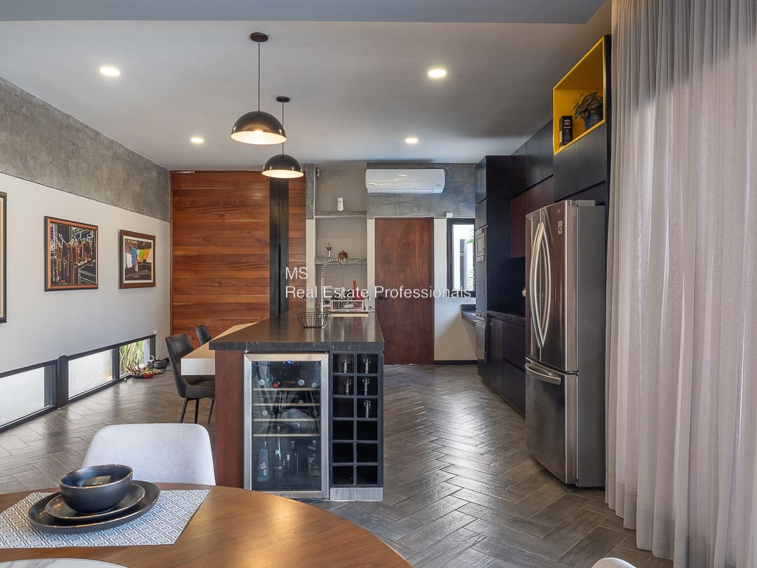 A kitchen with a wine cooler and refrigerator.