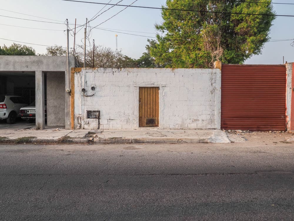 A white building with a door and window on the side of it.