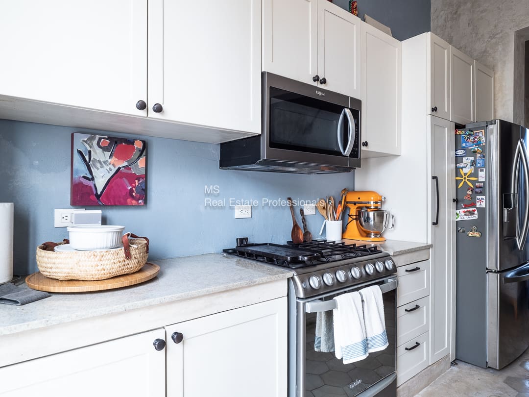 Bright kitchen with white cabinets and appliances.