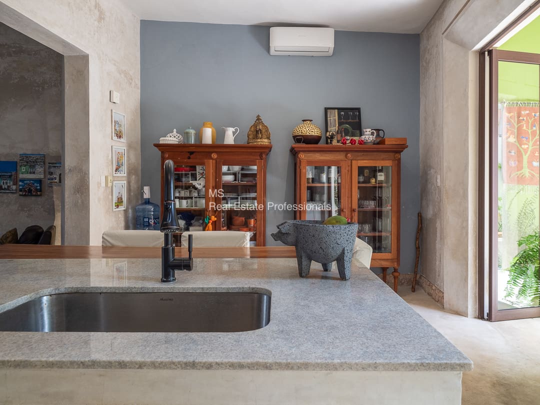 Kitchen sink, granite countertop, wooden cabinets.