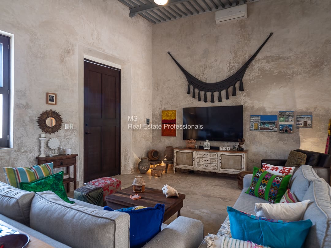 Bohemian living room with TV and comfy sofas.