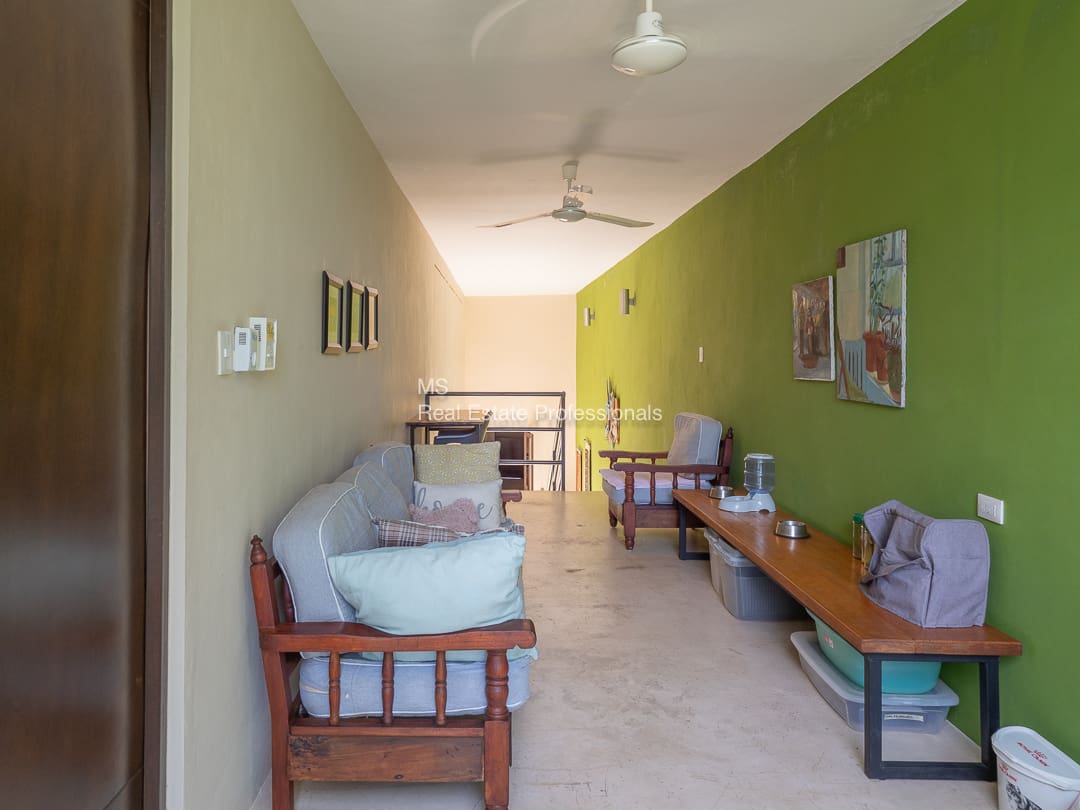 Long hallway with couch and pet station.
