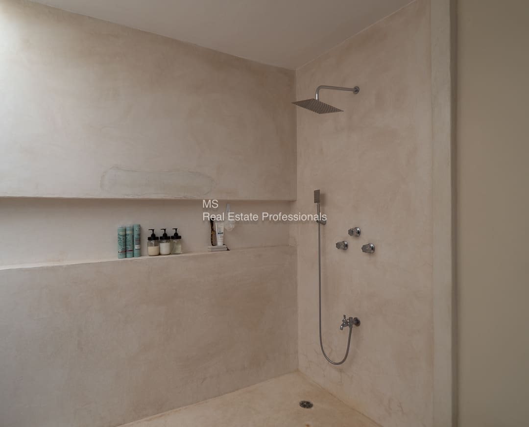 Modern shower with shelf and toiletries.