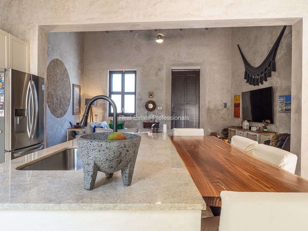 Modern kitchen with wood island and fruit bowl.