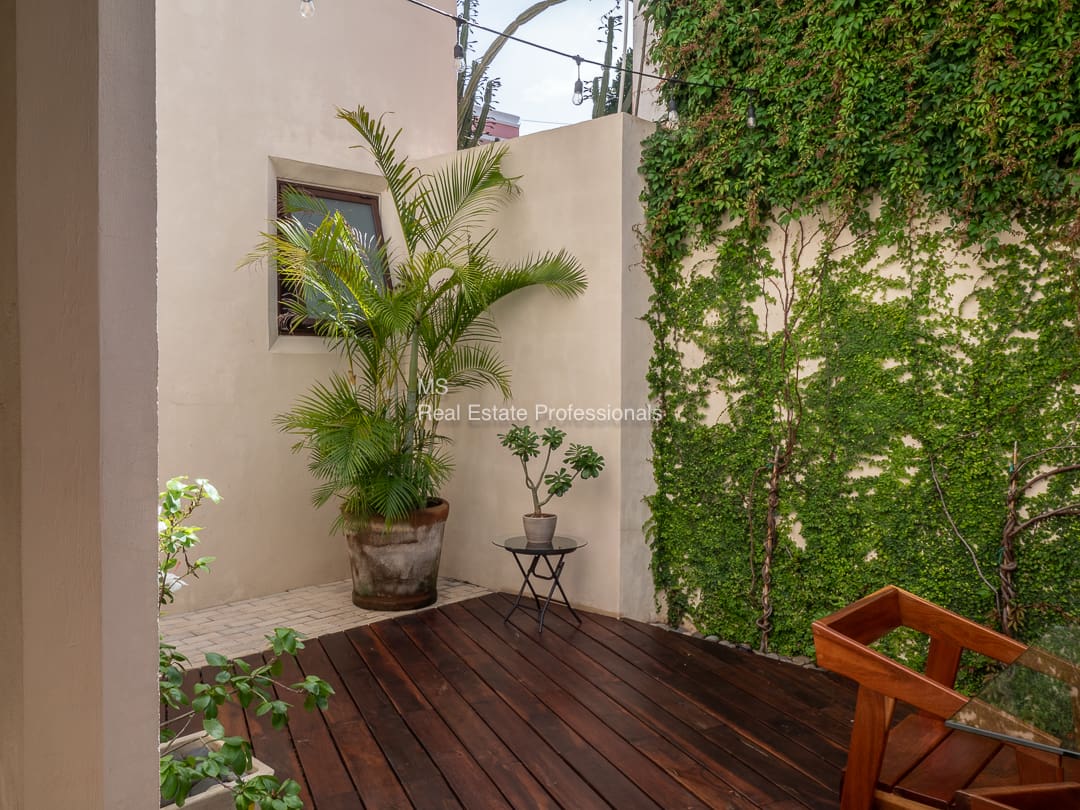 Wooden deck patio with potted plants.