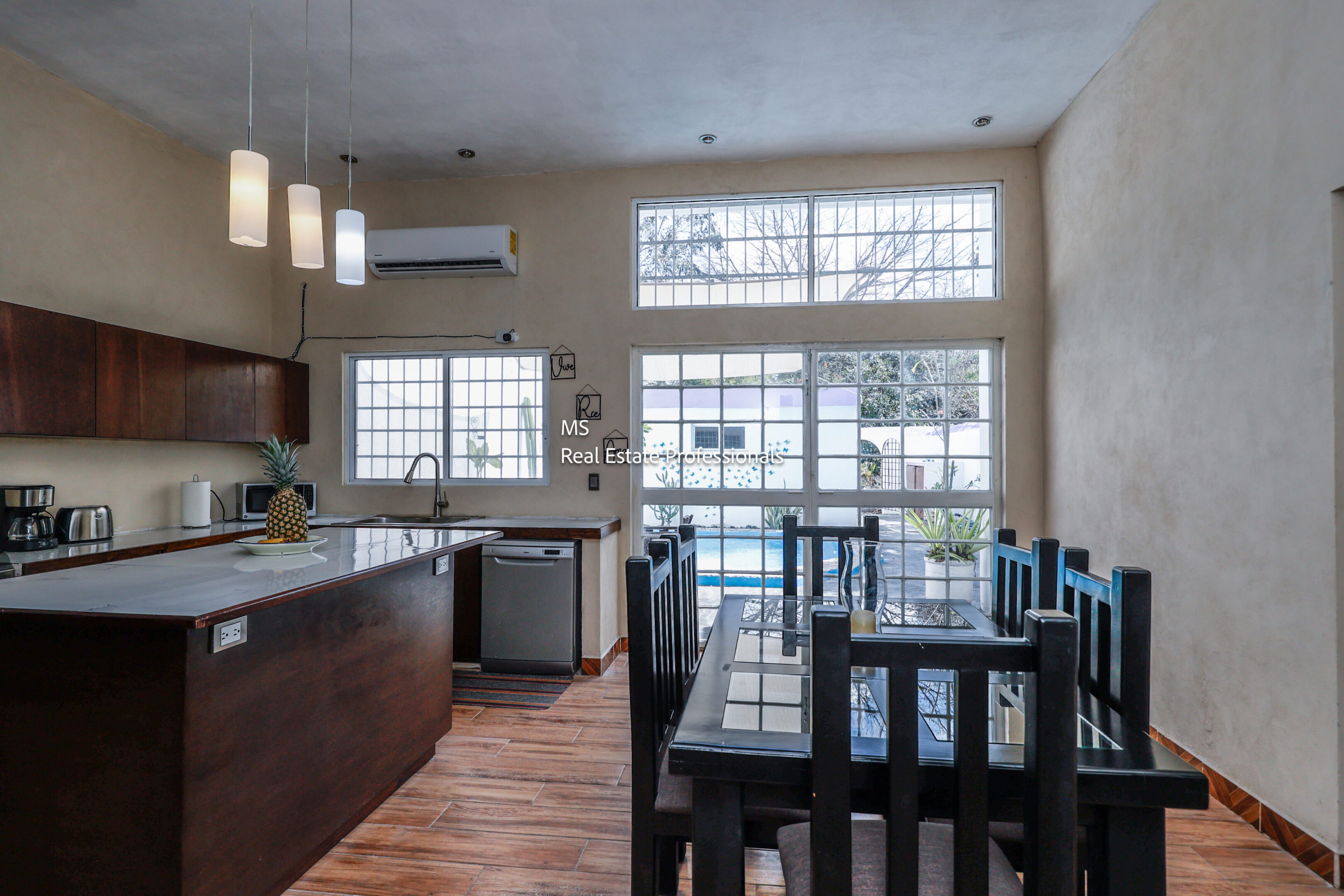 Modern kitchen and dining area with pool view.