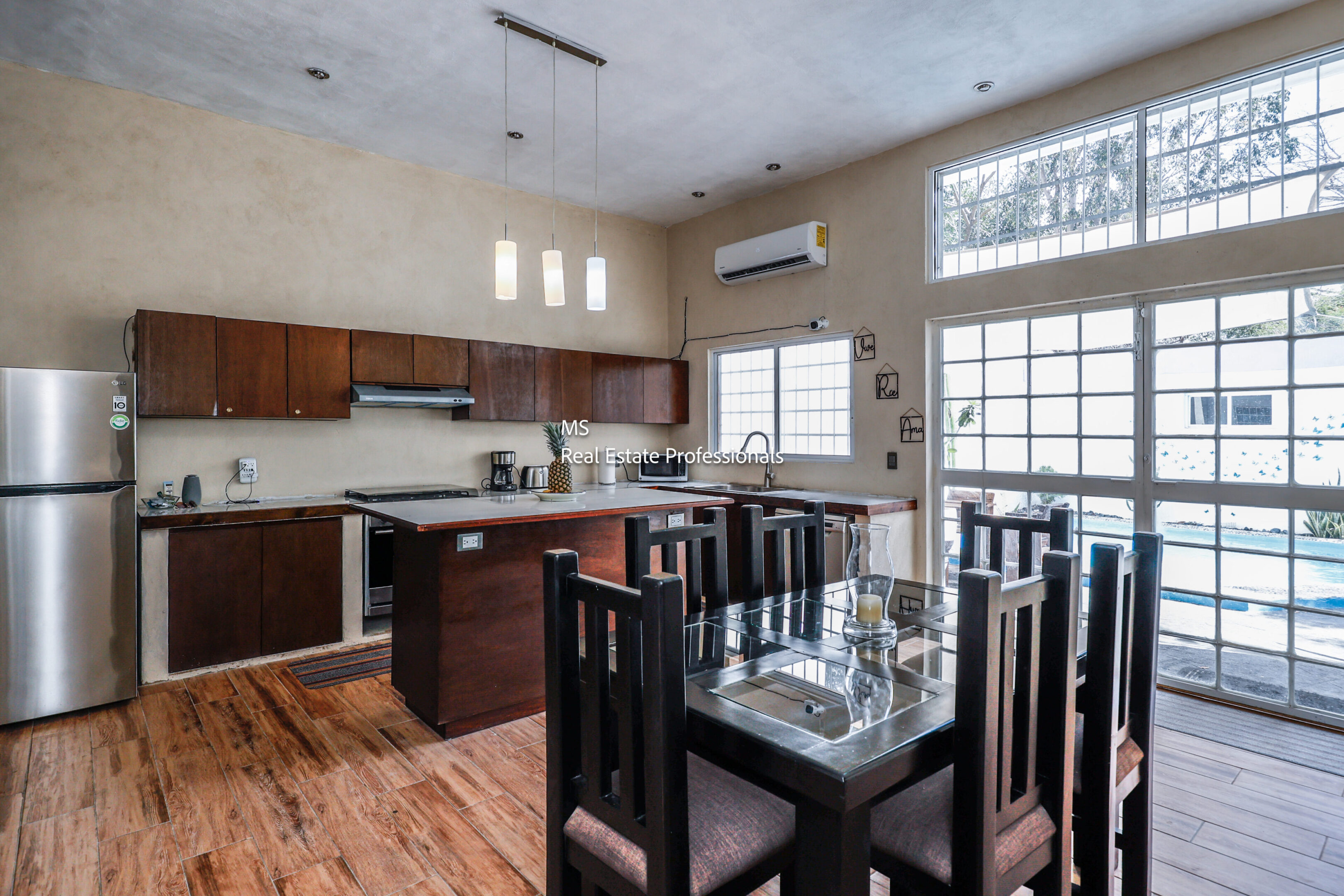 Modern kitchen with dining area and pool view.